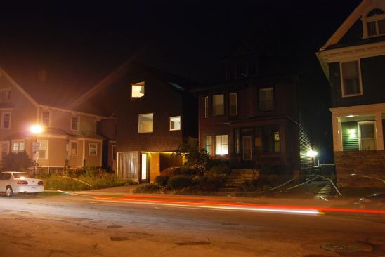 An evening streetscape shows the close proximity of neighboring houses.