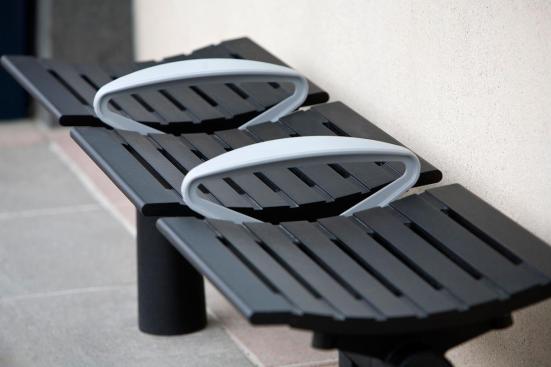 Tecno RS Seating System shown in three-seat, backless configuration with Black Texture powdercoated frame and seats, Silver Texture powdercoated low-profile horizontal armrests with polished upper surfaces, and cylindrical mounting posts at Sound Transit, Seattle, Washington