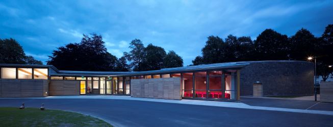 The building's low profile minimizes its impact on the site and surrounding neighborhood, in part by weaving through preexisting trees.