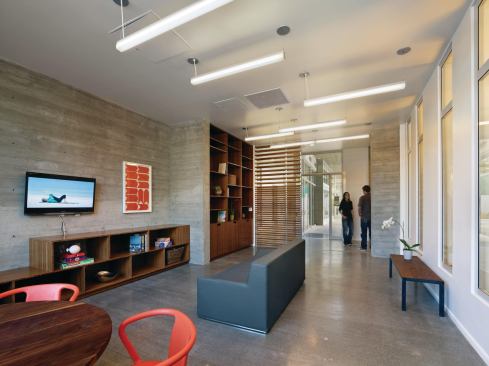 Ground-floor communal spaces, including the resident lounge, feature board-formed concrete walls and polished concrete floors.