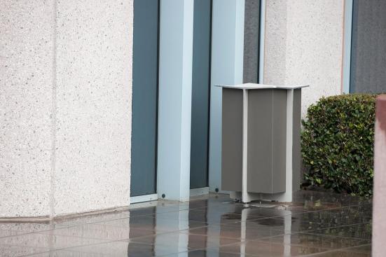 Knight Bench shown in 6 foot, backed configuration with Aluminum Texture powdercoated frame, FSC Pure Ip? hardwood slats and two armrests, and Knight Litter Receptacle with Slate Texture powdercoat at Mission City Corporate Center, San Diego, California