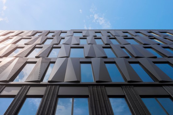 Like the metal panels, the building's windows mirror the sky.
