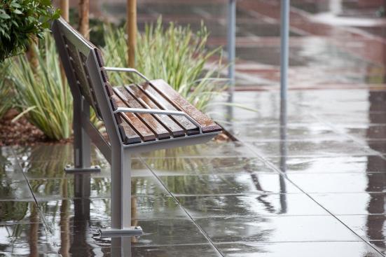 Knight Bench shown in 6 foot, backed configuration with Aluminum Texture powdercoated frame, FSC Pure Ip? hardwood slats and two armrests, and Knight Litter Receptacle with Slate Texture powdercoat at Mission City Corporate Center, San Diego, California