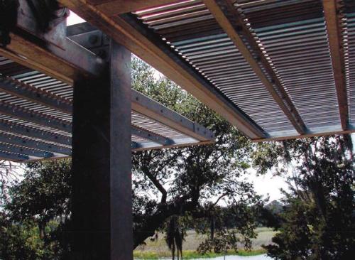 The screens sit about 12 feet out from the houses glass walls. Pushing them away from the home adds visual depth to open living spaces while creating a shady terrace overlooking Shim Creek.