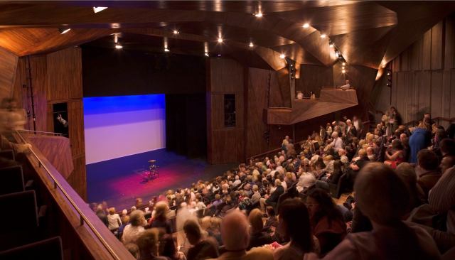 This auditorium shied away from symmetrical seating and instead twisted it 'like the crease of a hand.' The unorthodox seating pattern gives the audience a renewed perspective and enhances acoustics.