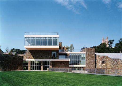 The project includes several green roof strategies. By applying field turf to the roof of an existing pool building (foreground), the architects created an outdoor recreation area directly off the student center. The glass guard rail on top of the cantilevered top story protects another planted green roof, this one with sedum and pavers. The next phase of the project will add a pavilion-like, glass-enclosed conference room to that top-most green roof, for use by faculty or for special events.