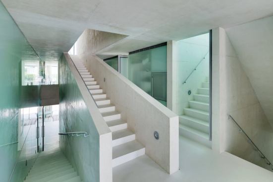 Circulation through the house follows two paths, a “fast stair” that moves directly from the basement level to the pool (seen at right), and a “slow stair,” with deeper risers, that winds through the interior (at left).