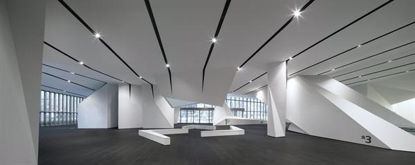 The+ground+floor+of+the+Model+Home+Gallery+showcases+the+ceiling+detail+designed+by+NADAAA.+Black-painted+channels+inscribed+in+the+ceiling+plane+(which+consists+of+white+Venetian+plaster+on+gypsum+board)+house+systems%2c+including+lighting%2c+sprinklers%2c+and+HVAC.