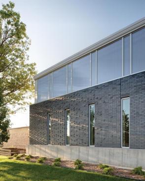 Narrow windows and translucent polycarbonate panels admit north light while addressing security concerns.