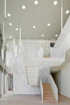 The+walls+in+the+ground-floor+lobby+are+clad+in+panels+that+mimic+the+articulation+of+the+concrete+fa%c3%a7ade.