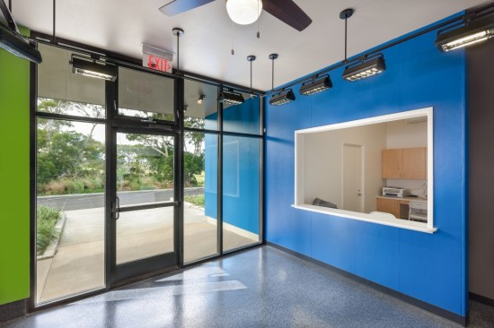 The blue plane visible on the main facade continues inside the treatment facility, forming the reception desk