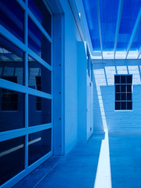 Detail+under+the+entry+canopy+showing+the+blue+polycarbonate+and+the+existing+steel+windows.+The+sun+creates+magical+changes+throughout+the+day.++The+space+remains+a+deep+blue+during+daylight+hours.