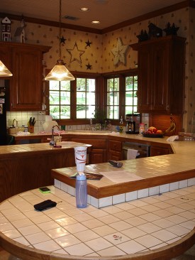 Before: Tile topped peninsula and corner kitchen sink. 