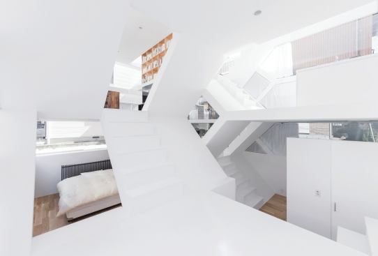 Scissoring staircases connect the split-level interiors, offering glimpses into the bedrooms, dining room, kitchen, and other spaces.