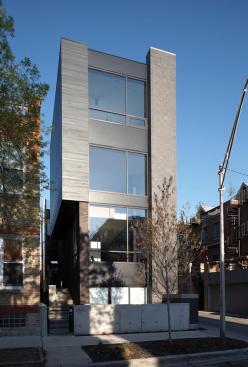 A mix of urban industrial materials including concrete block, brick, wood, and glass cover the front facade.