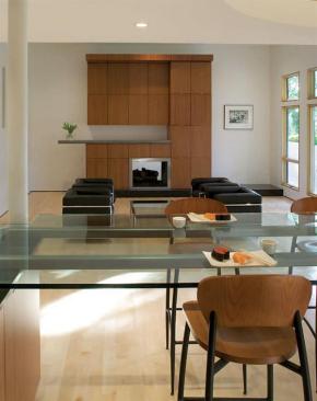 The redesign took its color and material cues from the owners cherry bar stools. The entertainment center across the room echoes the cherry kitchen cabinets and glass dining table.