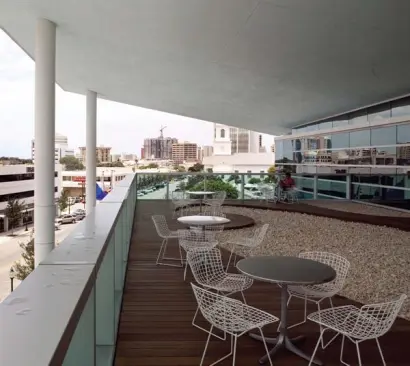 The creased roof of the Sarasota Herald Tribune headquarters is the building's signature. The design takes advantage of the local climate by integrating a deck accessible from the newsroom and by cladding the building in glass, so the sunlight can illuminate the interior during the day. Aluminum curtain-wall system - Owen Internationa - www.owenint.com Specifically designed curtain-wall system - Incorporates extruded aluminum mullions and Viracon glass - Different sized panels allow for differentiation along the exterior surface of the building Bertoia side chair - Knoll Studio - www.knoll.com Welded steel frame - Available in polished chrome or powder- coated paint - Cushioning options include seat, back, and complete - Greenguard certified Ipe wood decking - The Wood Company - www.thewoodcompany.net Custom deck over the entrance lobby - Solid ipe boards - Manufactured to accommodate winding gravel walk - Weather-treated to prevent rot
