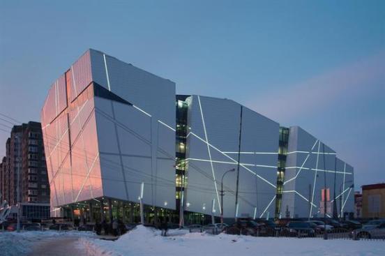 The web of coves cut into the fa?ade light up at dusk.