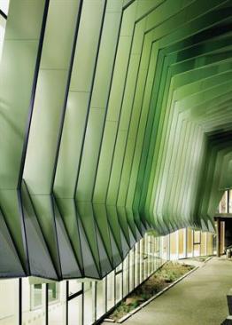 The+blades+are+clad+in+painted+aluminum+paneling.+Perforated+mesh+panels+between+blades+provides+solar+shading+for+the+ground+level.