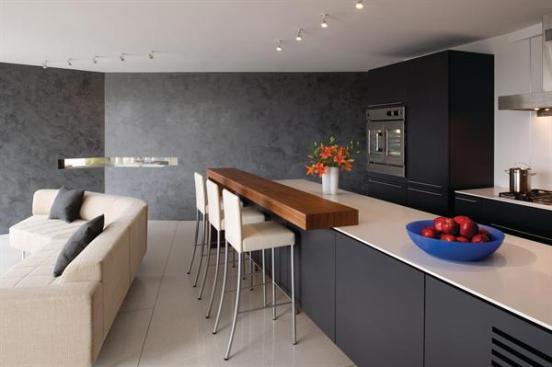 A V-shaped charcoal wall separates the kitchen/living area and the master bedroom behind it.