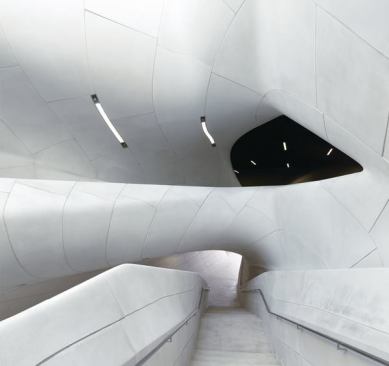 At+the+center+of+the+building+is+a+curvaceous+atrium+with+a+staircase+leading+to+the+second-level+galleries.