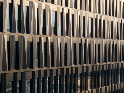 The façade shifts from black to white, silver, and gold, depending on the changing daylight.