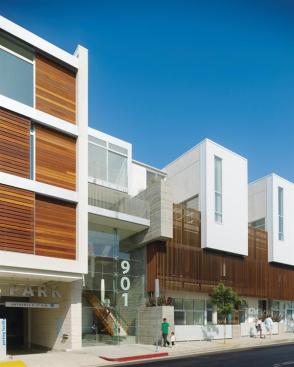 A glass and concrete entryway marks the transition from the flats/retail portion to the townhouses and studios on Hancock Avenue. 
