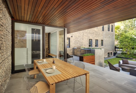 Backyard includes an outdoor kitchen, large table, and ample seating