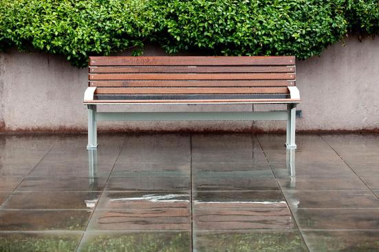 Knight Bench shown in 6 foot, backed configuration with Aluminum Texture powdercoated frame, FSC Pure Ip? hardwood slats and two armrests, and Knight Litter Receptacle with Slate Texture powdercoat at Mission City Corporate Center, San Diego, California