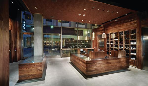 The cash wrap in the main reception space is a microcosm of the overall materials palette--which includes American black walnut, stainless steel, cork fabric, and concrete. EGRESS SIGNAGE - Sure-Lites - ELX Series recessed exit sign - sureliteslighting.com - RECESSED DOWNLIGHTS - LiteFrame - 4" recessed low-voltage downlights - prescolite.com/brands/liteframe.php