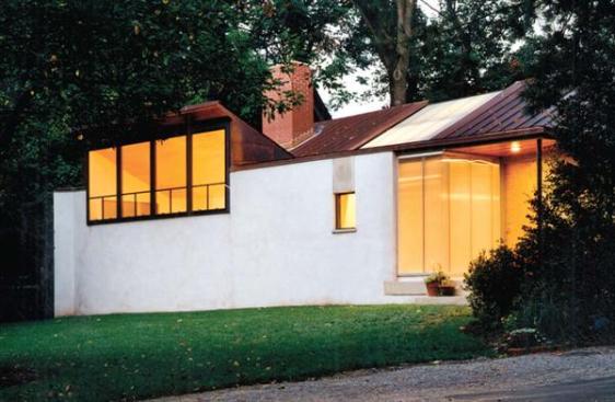 Before the renovation (far left), the house had little connection to the wooded yard and protected parkland beyond. The updated version (above), with its 10-foot-by-10-foot steel grid of windows and doors, offers direct connections to the outdoors. The master suites windows are elevated for privacy because they face the street (left). To increase the flow of natural light, polycarbonate panels substitute for walls and roofing.