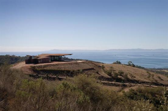 The house sits lightly on the land, and its fire-resistant glass, steel, and concrete exterior is designed to blend in.