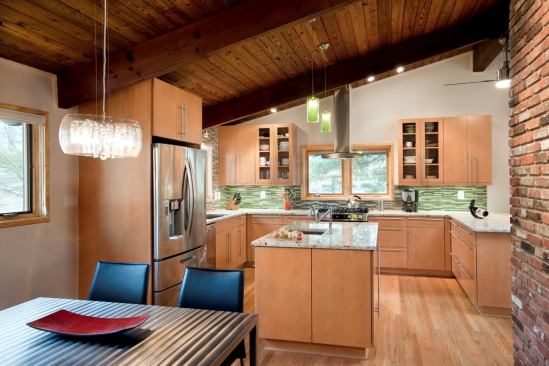 After: The kitchen was moved to the former dining room location in the corner of the house. The additional exterior walls accommodate cabinets while the kitchen opens up to the adjacent dining area.