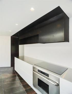 Knife edge stainless steel counters top the gloss white base cabinets. The uppers are acid washed steel.