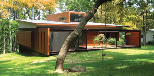The cedar-sided entry addition periscopes through the house as a circulation spine, emerging at rooftop level in the form of a loftlike study.