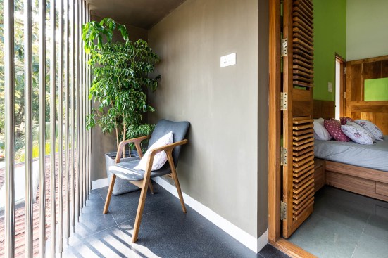 Bedroom 03 extends to shaded balcony with vertical railing overlooking the approach road. Space becomes a morning spot to read and enjoy the sunrise