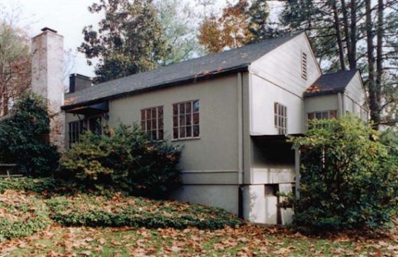 Before the renovation (far left), the house had little connection to the wooded yard and protected parkland beyond. The updated version (above), with its 10-foot-by-10-foot steel grid of windows and doors, offers direct connections to the outdoors. The master suites windows are elevated for privacy because they face the street (left). To increase the flow of natural light, polycarbonate panels substitute for walls and roofing.