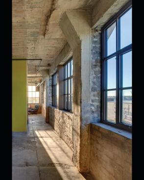 The clean-lined aesthetic of the inserted elements counterpoints the buildings exposed structure and mechanical systems.