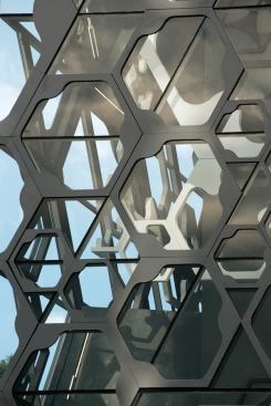 Up close, the layers of the façade become evident. The outer layer is black fiberglass, followed by matte aluminum, and finally white stainless steel.