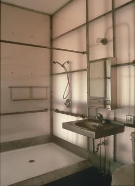 The house's materials are either sustainable or from the recycling bin. The wood exterior is red-stained okoume, anAfrican import. When the lights are on, a wedge of Lexan glows between the garage and the angled aluminumshingleroof. The open kitchen has c