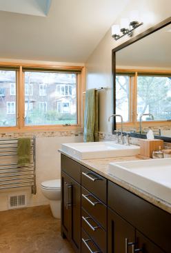 After: New fixtures and finishes as well as a new skylight have turned this once-dated bathroom into a luxurious amenity (note the heated towel racks!).