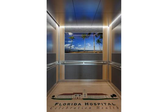 LEVELe-102 Elevator Interior with main panels in Bonded Aluminum with Dark Patina and Grass pattern; small accent panels in White Birch wood veneer; handrail panels in Stainless Steel with Sandstone finish; Compass handrails in Satin Stainless Steel at Florida Hospital Celebration Health, Celebration, Florida
