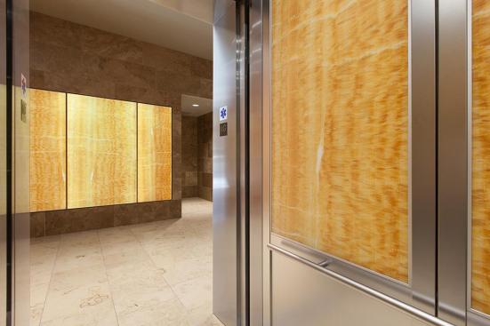 LightPlane Panels in ViviStone Honey Onyx with Pearlex finish shown illuminated; also shown, CabForms Series 2000-N Elevator Interior with upper inset panels in ViviStone Honey Onyx, Pearlex finish; lower inset panels in Stainless Steel, Linen finish; stiles and rails in Stainless Steel, Seastone finish; Sextant Handrails at the Woolworth Building, Eugene, Oregon