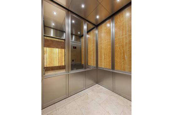 CabForms Series 2000-N Elevator Interior with rear wall upper inset panels in Stainless Steel, Mirror finish; side wall upper inset panels in ViviStone Honey Onyx, Pearlex finish; lower inset panels in Stainless Steel, Linen finish; stiles and rails in Stainless Steel, Seastone finish; Sextant Handrails at the Woolworth Building, Eugene, Oregon