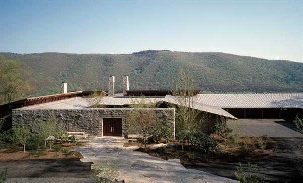 Terne coated metal roofs, weathered to slate gray, outline the central stone courtyard and the car court.