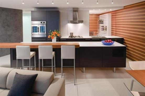 A walnut wall panel with ribbed graining unifies the living room, kitchen, and wine room beyond. 