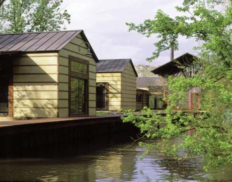 A simple boardwalk connects a sequence of small buildings with the screened in boathouse. "We're excited about the notion of a village along a canal," says principal in charge Ted Flato.
