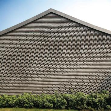 The+masonry+courses+alternate+at+varying+depths+to+create+a+play+of+light+and+shadow+across+the+wall+surface.