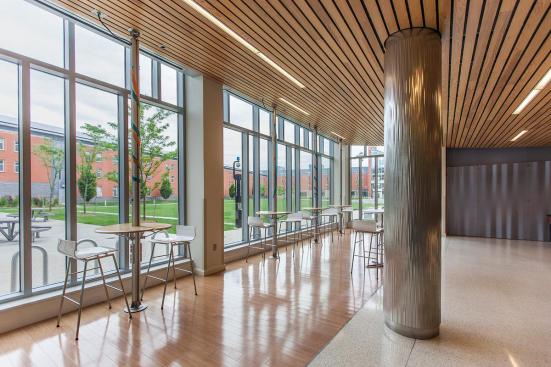 Column in Stainless Steel with Sandstone finish and Kalahari Impression pattern, and Profile One Information Kiosks shown in single-mast configuration with wood table tops at Salem State University, Salem, Massachusetts
