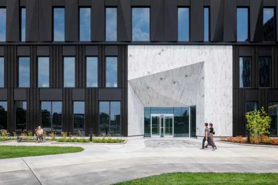 A change in texture and material marks the building's entrance.